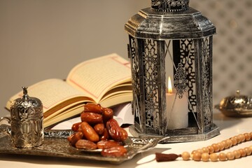 Arabic lantern, Quran, misbaha and dates on white table