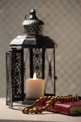 Fototapeta na wymiar Arabic lantern, Quran and misbaha on white table