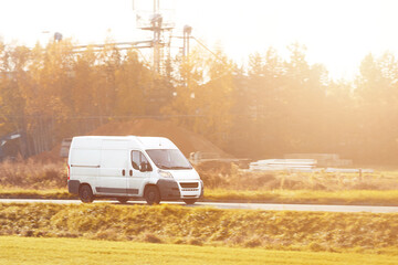 delivery van carries parcels along a sunlit road, ensuring timely service and customer satisfaction.