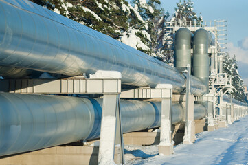 pipelines in winter against the backdrop of forest and blue sky