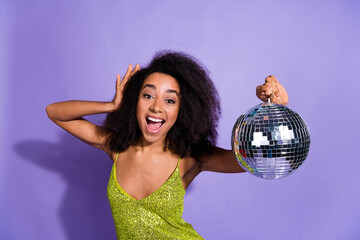 Photo portrait of gorgeous young girl dancing hold discoball wear trendy green sequins outfit isolated on purple color background