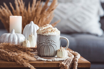 A seasonal drink. Delicious pumpkin latte with whipped cream and cinnamon in a mug on a wooden...