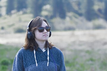 Woman wearing headphones enjoying nature.