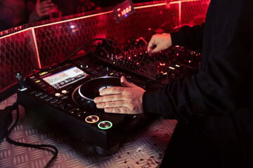 Close up view of a dj's hands playing the mixer while performing