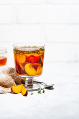 flavored black tea with plums, berries and thyme on white background, vertical