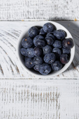 fresh blueberries in a white bowl, vertical