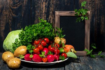 plate with fresh seasonal vegetables and black background for text, horizontal