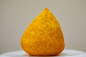 Traditional fried coxinha on a wooden table in selective focus - Brazilian snack