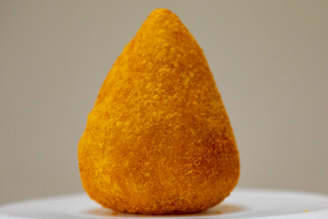 Traditional fried coxinha on a wooden table in selective focus - Brazilian snack