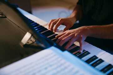 person's hands playing a piano
