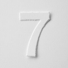 The number seven is made of white paper on a white background.