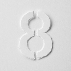 The number eight is made of white paper on a white background.