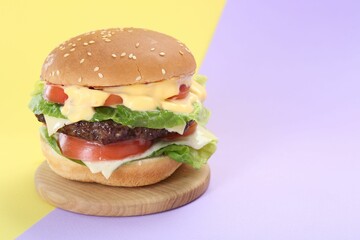 Burger with delicious patty on color background. Space for text