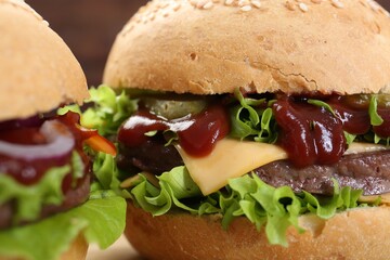 Delicious cheeseburgers with lettuce, pickle, ketchup and patty, closeup