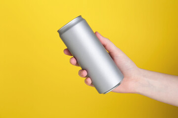 Woman with energy drink on yellow background, closeup