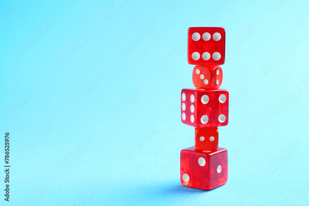 Sticker Many stacked red game dices on light blue background, closeup. Space for text