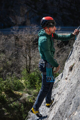 Fototapeta premium Caucasian male with black hair. Practicing rock climbing looking straight ahead.