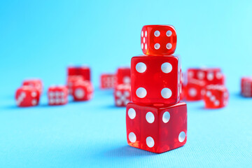 Many red game dices on light blue background, closeup