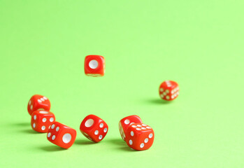 Many red game dices falling on green background. Space for text