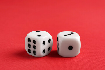 Two white game dices on red background, closeup