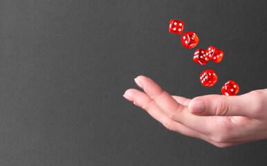 Woman throwing game dices on black background, closeup. Space for text