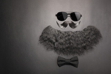 Flat lay composition with artificial moustache and sunglasses on black background, space for text