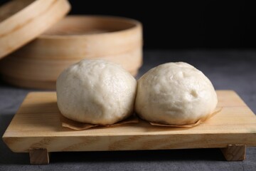 Delicious Chinese steamed buns on grey textured table, closeup