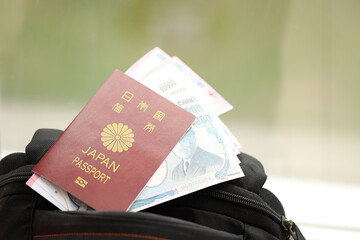 Japan passport with japanese yen money bills with airline tickets on backpack close up