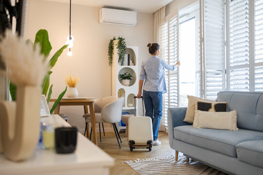 Young woman with her suitcase in a rented apartment

