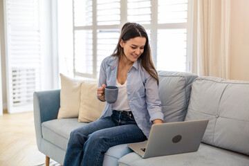 Portrait of smiling woman working on laptop at home
