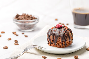 Round chocolate cakes. Decorated with candied raspberries. Light background.
