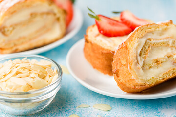 Obraz na płótnie Canvas Sliced rolls with custard. The dessert is decorated with fresh strawberries.
