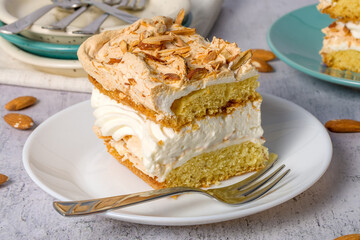 Norwegian cake. With meringue, whipped cream and almonds. Light background.