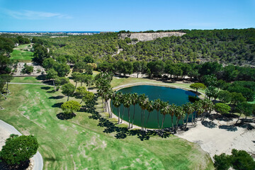 Drone point of view golf course on tropical nature with green lake during sunny summer day. Places, lifestyle, sport concept