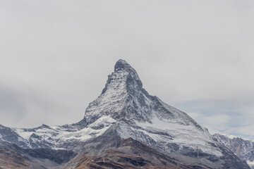 Snowcapped mountain with cloudy sky creates a mystical natural landscape