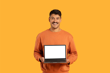 Guy presenting laptop with blank screen to camera - obrazy, fototapety, plakaty