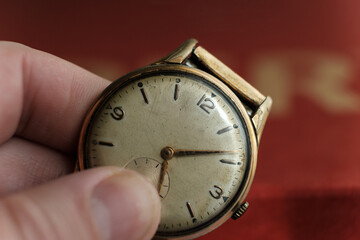 Authentic wristwatch held by fingers.