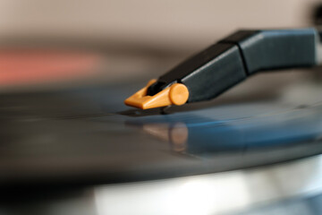 Side macro view of needle turntable playing a record.