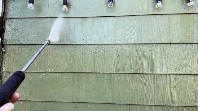 Power washing house siding close up in slow motion