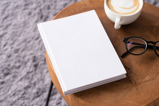 blank book mockup on coffee table with decorations and grey rug