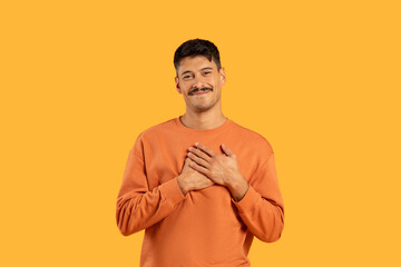 Smiling man in orange shirt on yellow