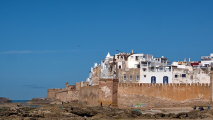 City walls around the old medina, above the rugged, Atlantic coastline, seen from the port in Essaouira, Morocco