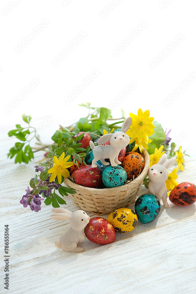 Wall mural easter holiday. cute easter bunny and colorful eggs with flowers on table, white background. festive