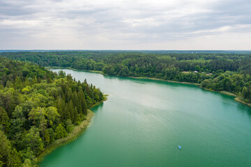 Obraz na płótnie Canvas Aerial view of beautiful Balsys lake, one of six Green Lakes, located in Verkiai Regional Park. Birds eye view of scenic emerald lake surrounded by pine forests. Vilnius, Lithuania.