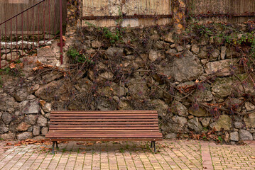 Tranquil Wooden Bench Amidst Stone and Greenery