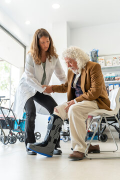 Senior man tries on an orthopedic boot at the pharmacy