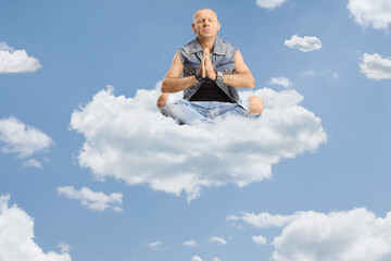 Man sitting corssed legged and practicing meditation on a cloud in the sky