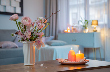 home interior with spring flowers and burning candles - 786560753