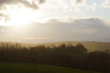 sun shines over rolling hill landscape