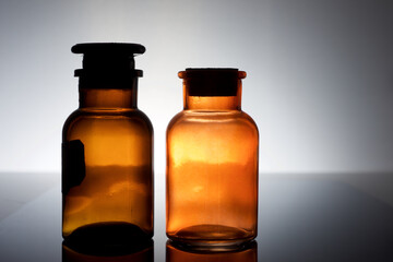 Amber laboratory bottles on a black table